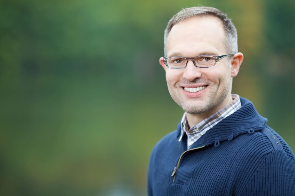 Mężczyzna uśmiecha się do zdjęcia i pokazuje swoje zęby